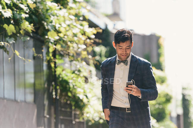 Stylish businessman choosing smartphone music, West Village, Manhattan, USA — Stock Photo