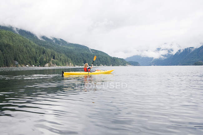 Woman kayaking in fjord — Stock Photo