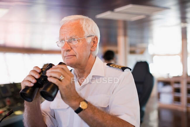 Capitán en la nave sosteniendo un telescopio - foto de stock