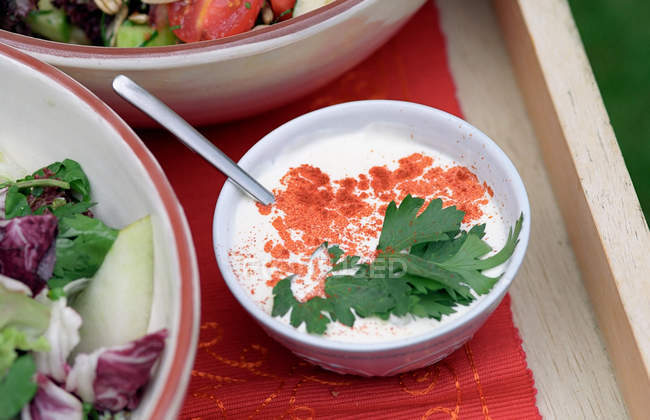 Свіжі салати і соус в мисках — стокове фото