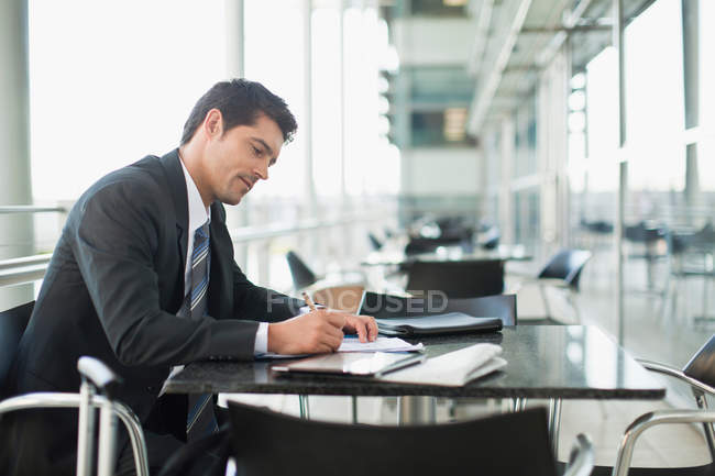 Businessman making notes in cafe — Stock Photo