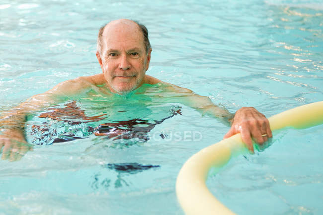 Літній чоловік плаває в басейні — стокове фото