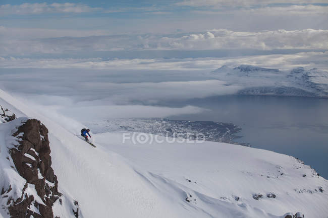 Homem de snowboard descendo montanha em Eskifjordur, Islândia — Fotografia de Stock