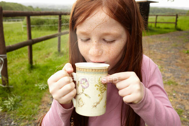 Girl drinking cocoa outdoors — Stock Photo