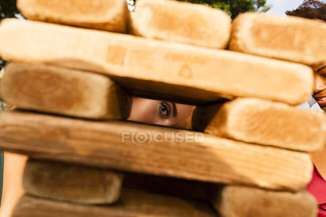 Mujeres jóvenes espiando a través de bloques de construcción - foto de stock