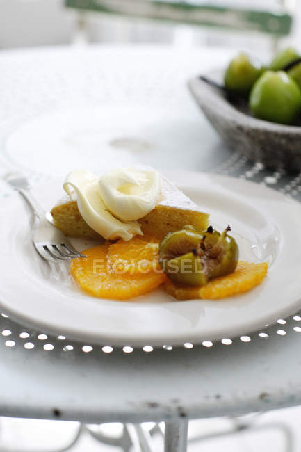 Plate of cake with fruit and cream — Stock Photo