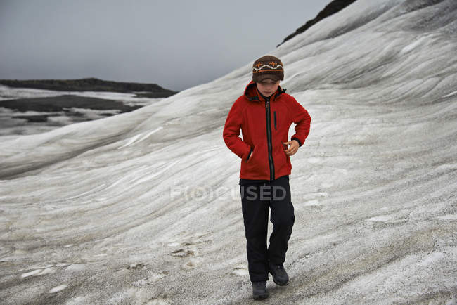 Chica caminando en la ladera nevada - foto de stock