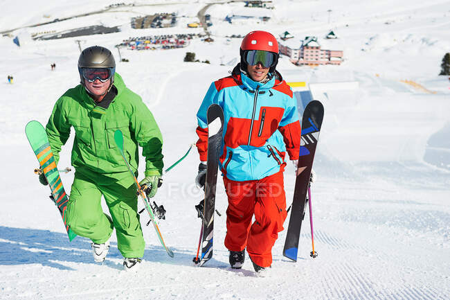 Esquiadores llevando equipo cuesta arriba - foto de stock