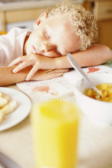 Boy sleeping at breakfast — Stock Photo