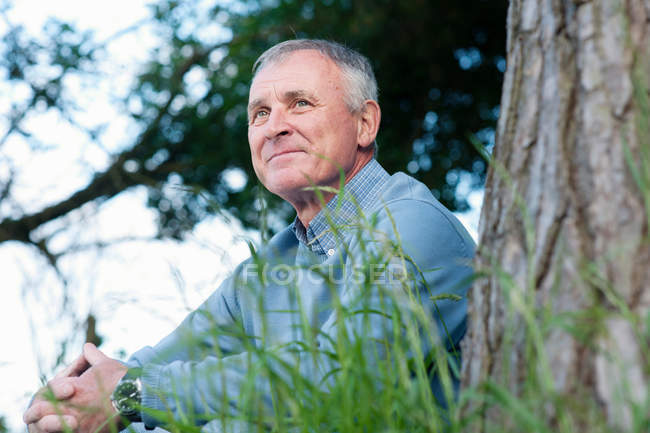 Man leaning against tree — Stock Photo