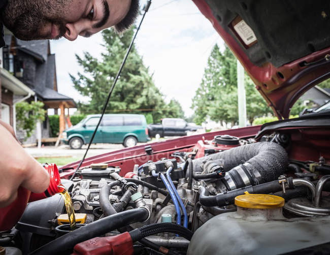 Чоловік, що працює на двигуні автомобіля, вибірковий фокус — стокове фото