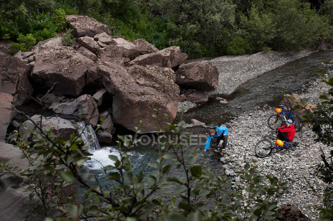 Paar überquert Bach mit Fahrrädern, selektiver Fokus — Stockfoto