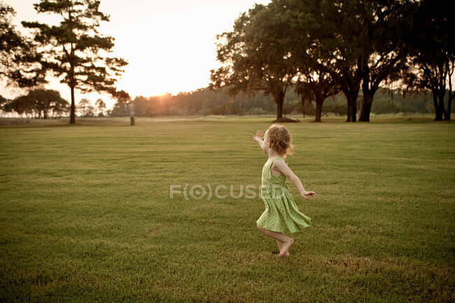 Menina da criança correndo no campo gramado — Fotografia de Stock