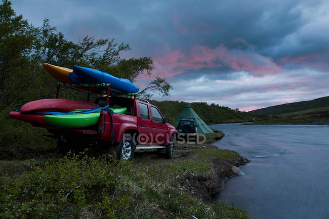 Canoas em caminhão cama por rio — Fotografia de Stock
