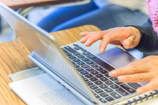 Manos de estudiante madura femenina escribiendo en el portátil en clase - foto de stock