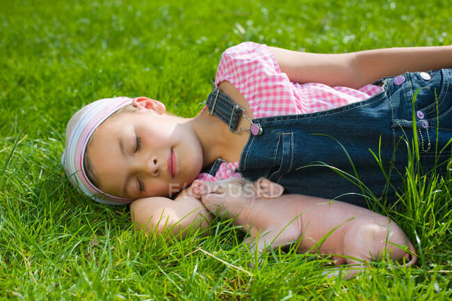A girl and a piglet sleeping — Stock Photo