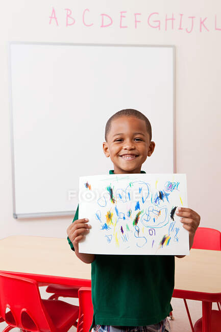 Junge mit Bild, das er in der Schule gezeichnet hat — Stockfoto