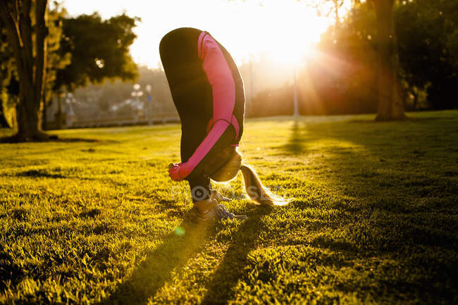 Woman stretching in park — Stock Photo