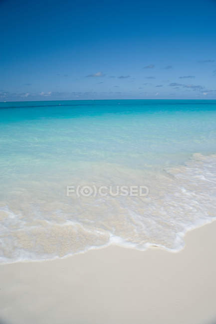Waves on sandy beach — Stock Photo