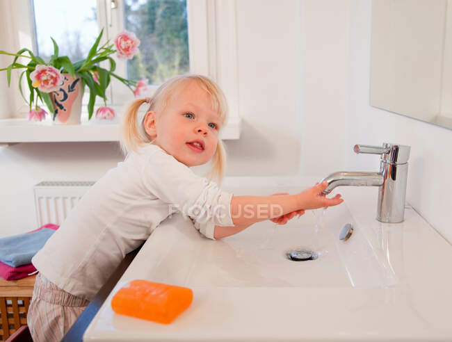 Маленькая девочка, моющая руки — стоковое фото
