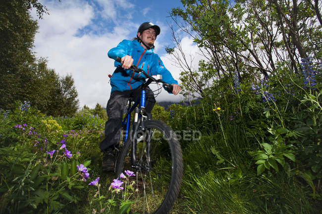 Человек на горном велосипеде по грунтовой дороге — стоковое фото