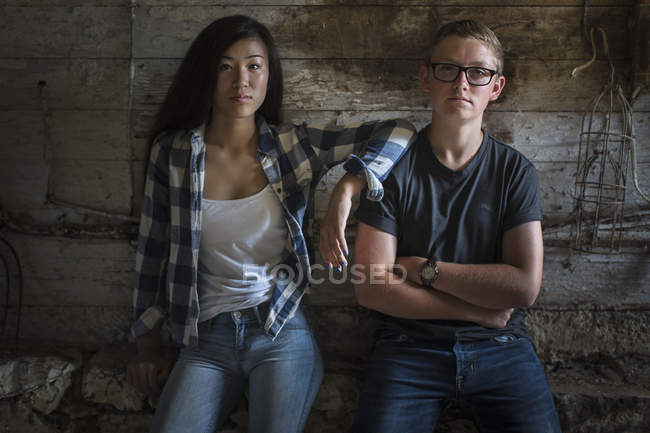 Ritratto di giovane coppia nel vecchio fienile guardando la fotocamera — Foto stock