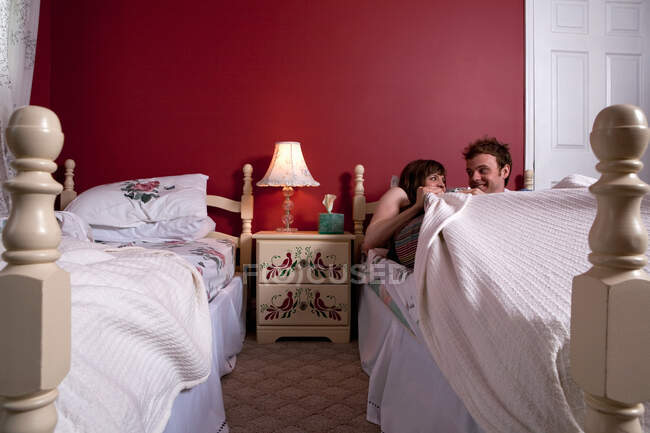 Jeune couple partageant un lit simple — Photo de stock