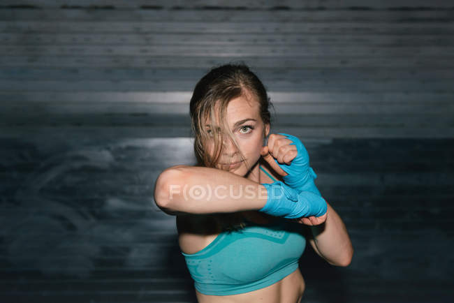 Young woman working out, boxing, outdoors, at night — Stock Photo