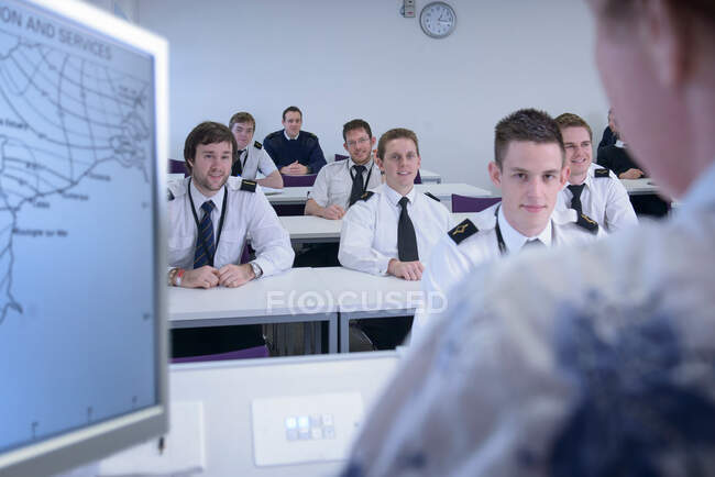 Students listening to tutor in shipping training room — Stock Photo
