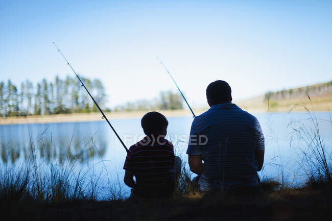 Батько риболовля з сином в озері — стокове фото