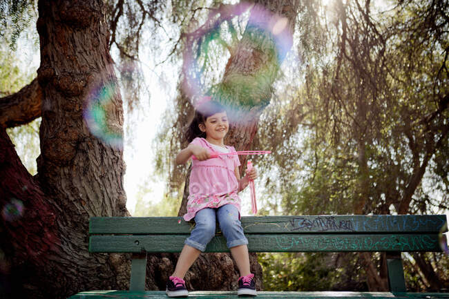 Girl playing with soap bubbles — Stock Photo