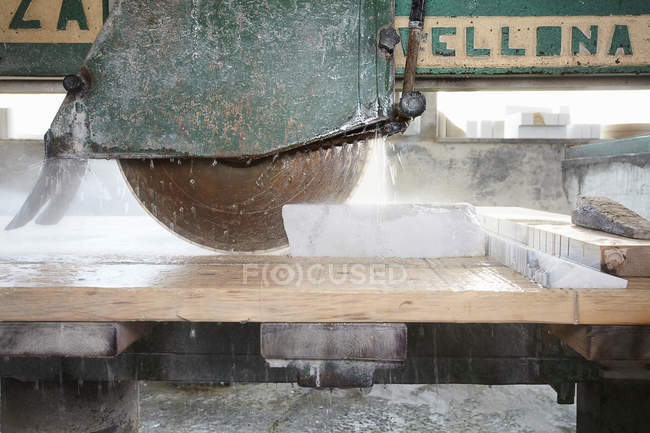Machinery cutting stone on board — Stock Photo