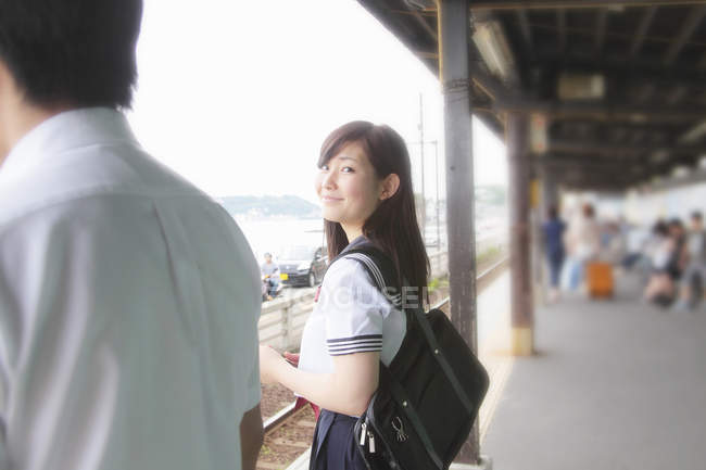 Молода жінка на залізничній платформі дивиться на камеру — стокове фото