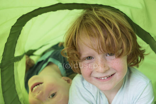 Two young boys playing in play tube — Stock Photo