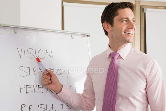 A lecturer pointing at whiteboard — Stock Photo