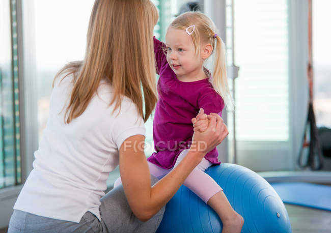 Girls playing with exercise ball in gym — Stock Photo