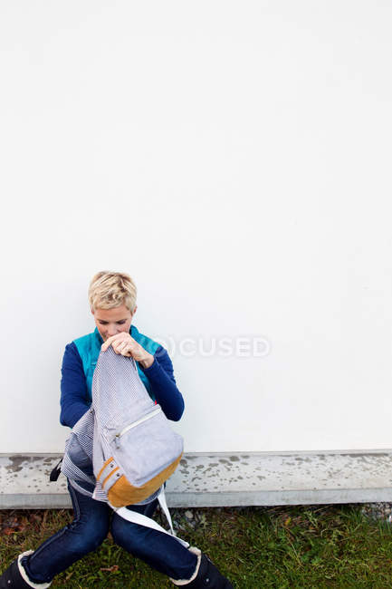 Woman digging through backpack — Stock Photo