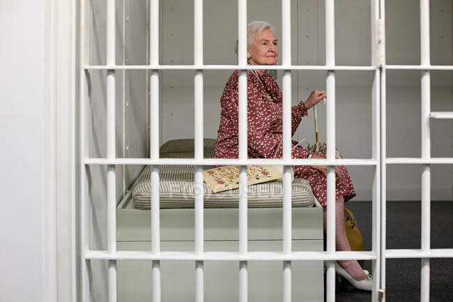 Senior woman in prison cell — Stock Photo