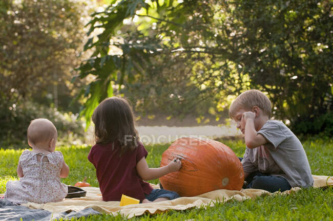 Children drawing on pumpkin — Stock Photo