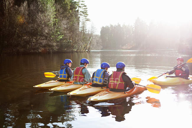 Profesor hablando con estudiantes en kayaks - foto de stock