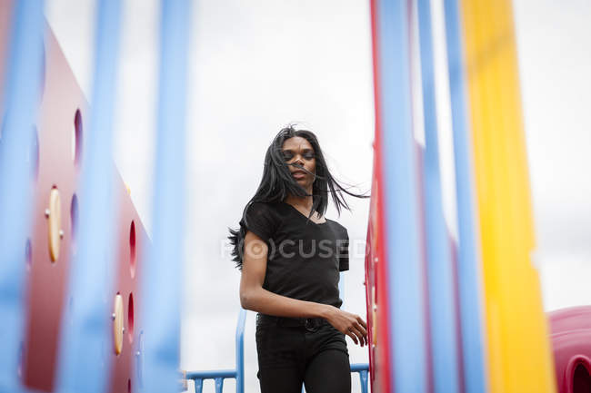 Молодий чоловік з довгим волоссям на дитячому майданчику — стокове фото