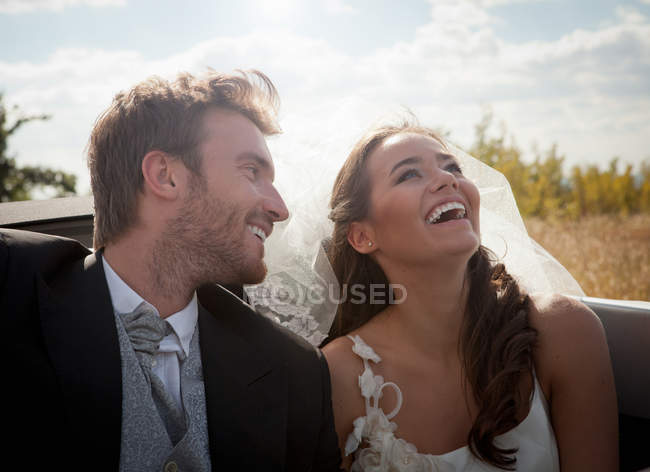 Newlywed couple sitting in convertible — Stock Photo