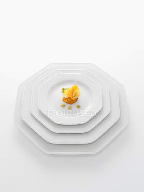 Vista de cerca del delicioso aperitivo gourmet en plato blanco aislado en blanco - foto de stock