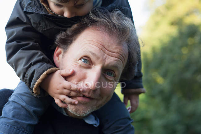 Батько носить сина на плечах — стокове фото