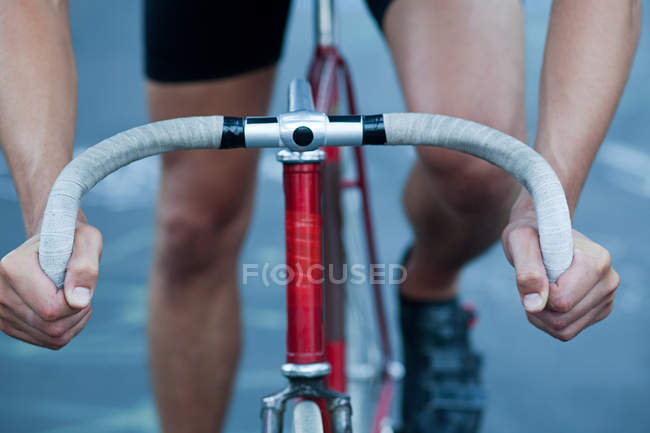 Hands of cyclist and handlebars, cropped shot — Stock Photo