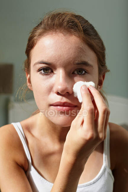Adolescente menina limpeza seu rosto — Fotografia de Stock