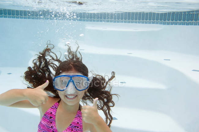 Chica dando pulgares hacia arriba bajo el agua, enfoque selectivo - foto de stock