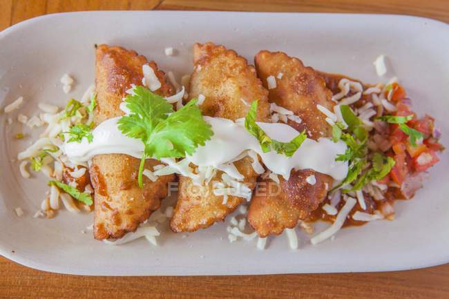 Aruban pastries with sauce and garnish on plate — Stock Photo