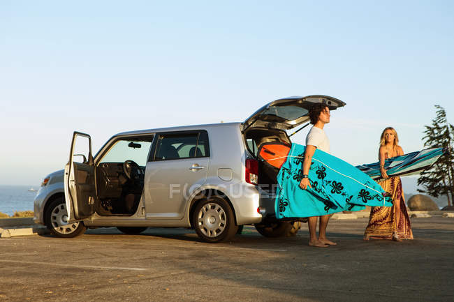 Пара, берущая доски для серфинга из багажника автомобиля — стоковое фото