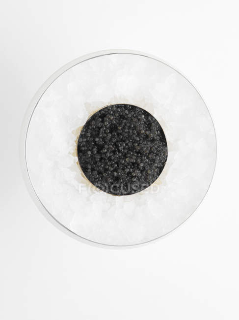 Caviar negro en lata sobre hielo picado, vista superior - foto de stock
